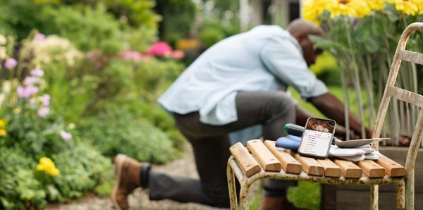 Un papa qui jardine avec son babyphone Avent Connect