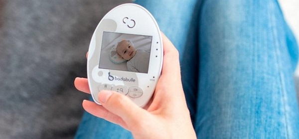 une maman qui regarde une vidéo sur son récepteur de Baby Online Video